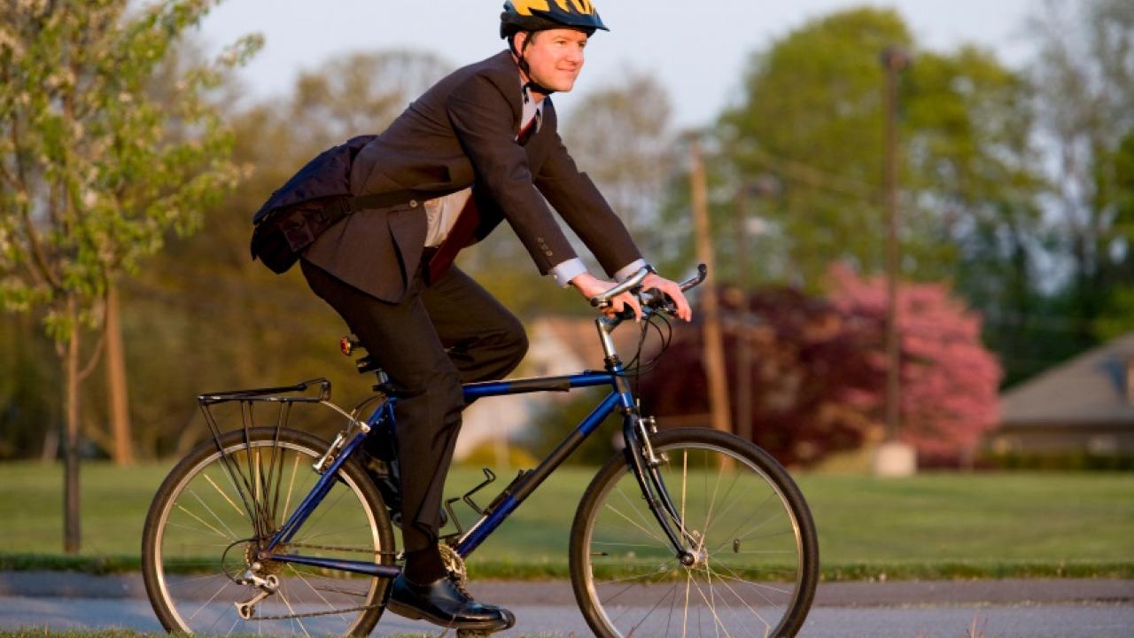 Person biking to work in a suit